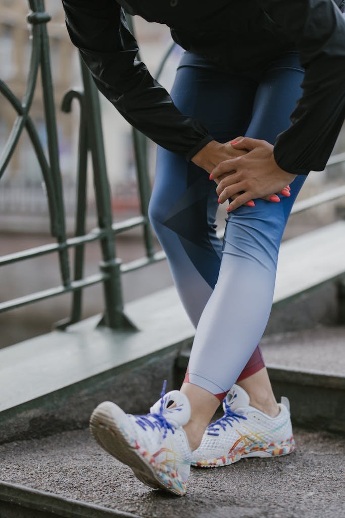 Person in sportswear stretching on outdoor steps, promoting fitness and wellness.